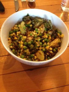 sharing dish of brussel sprouts, peas and corn